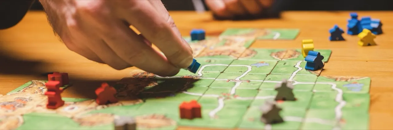 A group of friends gathered around a table playing board games in a private themed room at Secret Hangout in Orlando
